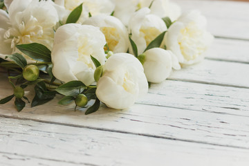 Bouquet of white peonies on the old white wooden boards