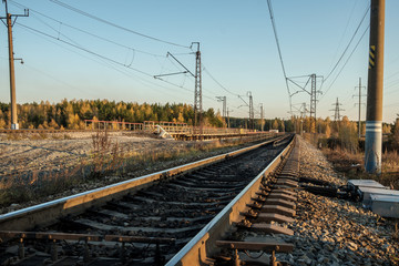 Fototapeta na wymiar railway tracks stretching into the distance, the prospect of autumn and the sunset at the end of the day