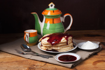Still life of pancakes to pour the berry syrup,
