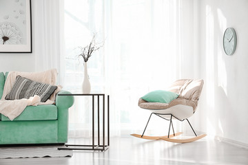 Living room interior with comfortable mint couch and rocking chair