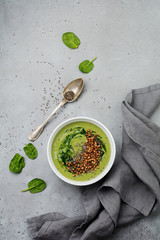 Useful smoothies from spinach with buckwheat flakes in ceramic bowls on gray concrete table background. Selective focus. Top view. Copy space.