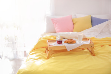 Fototapeta na wymiar Tray with tasty breakfast on bed