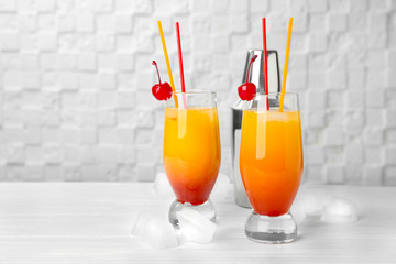 Glasses with cocktail Sex on the Beach against white wall