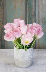 Bouquet of pink tulips, rustic wooden background.