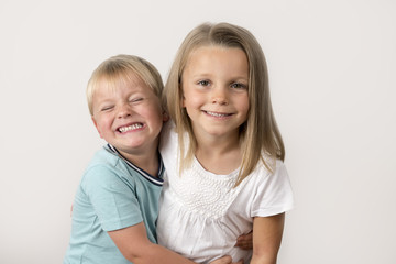 7 years old adorable blond happy girl posing with her little 3 years old brother smiling cheerful isolated on white background