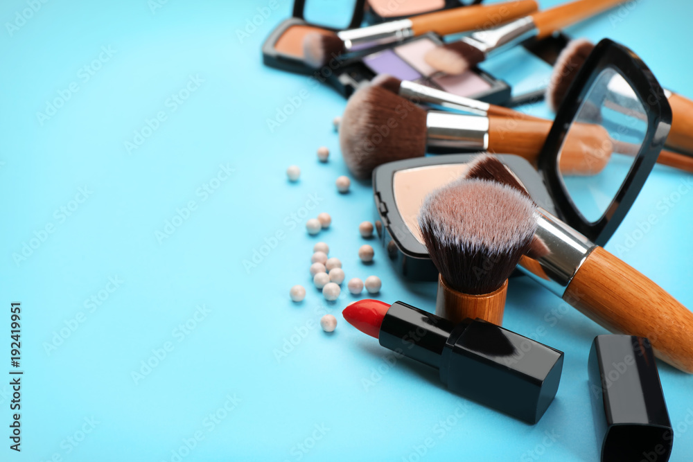 Wall mural Decorative cosmetics and tools of professional makeup artist on color background