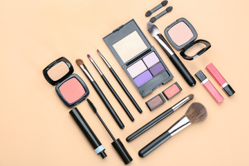 Decorative cosmetics and tools of professional makeup artist on color background