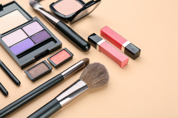 Decorative cosmetics and tools of professional makeup artist on color background