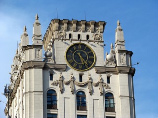 the clock tower close up,vintage clock tower old bas reliefs. blue sky background. Minsk