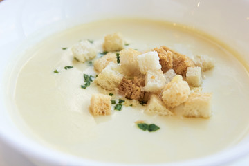 Small crackers. Delicious cheese soup. White dishes
