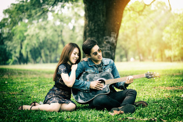 Couple in love playing guitar in the park
