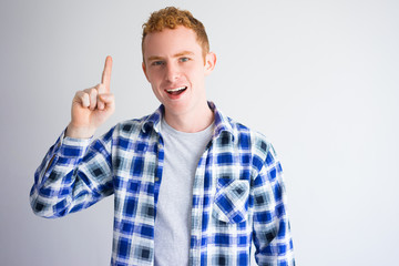 Portrait of excited young man showing idea gesture