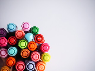 Top view Multi colored pens on a white background.