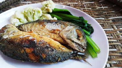 Thai food Mackerel fried and boiled vegetables on wood basket background.