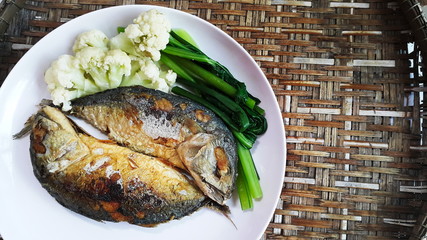 Thai food Mackerel fried and boiled vegetables on wood basket background.