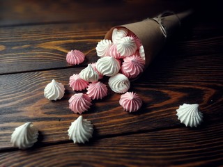 airy pink and white meringue on wooden background     
