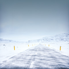 Winter road in iceland, wind and snow, blue sky