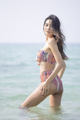 Fototapeta na wymiar Beautiful asian woman posing at the the ocean.