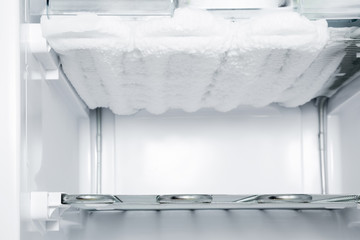 Frozen ice in the empty freezer. Problem and solution concept.