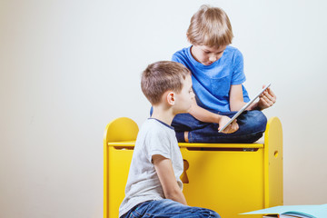 Children playing on tablet at home