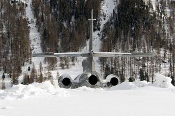 Rear view of a silver color private jet in the alps switzerland in winter