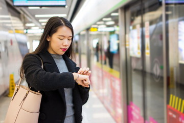 Girl checking time while waiting for the metro