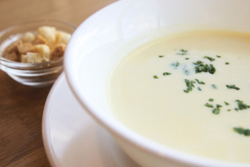 Delicious cheese soup. Small crackers. White dishes