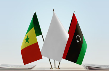 Flags of Senegal and Libya with a white flag in the middle