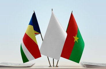Flags of Seychelles and Burkina Faso with a white flag in the middle