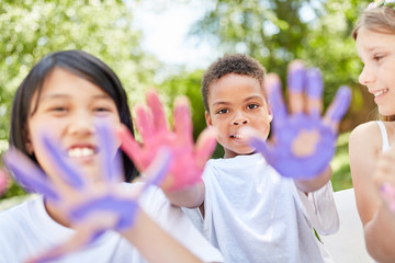 Kinder im Kindergarten malen mit Fingerfarben