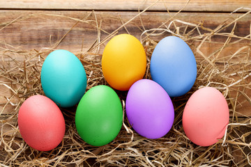 Fototapeta na wymiar Variety of colorful easter eggs on straw and wood