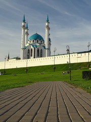 Widok Wielkiego Meczetu w Kazaniu, stolicy Tatarstanu w  Federacji Rosyjskiej, na pierwszym planie brukowany chodnik wiedzie do zielonego wzgórza na którym jest meczet, błękitne niebo  - obrazy, fototapety, plakaty