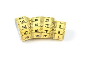 Yellow sewing measuring tape on white background