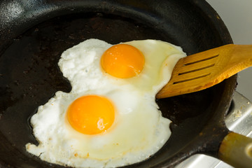 A couple of eggs for Breakfast. Fried eggs in a frying pan.