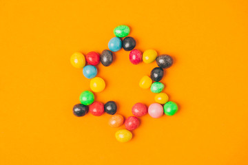 top view of star made of sweets isolated on orange, purim holiday concept