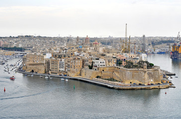 A beautiful port on the island of Malta with buildings, monuments and ships
