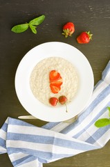 Healthy breakfast of oatmeal with strawberry and cherry