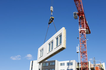 Industrial cranes lifting a wall on a construction site in Krista, Sweden