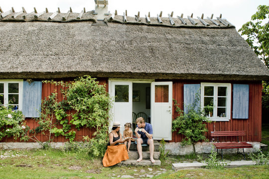 Family sitting on steps in Friseboda, Sweden