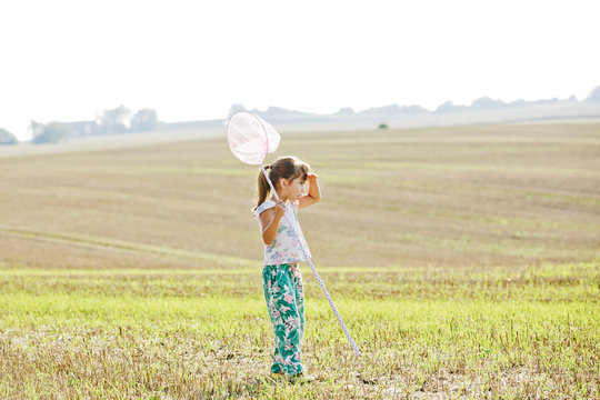 Girl with bug net in field in Friseboda, Sweden