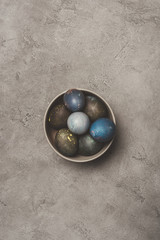 top view of easter eggs in bowl on concrete surface