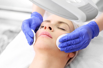 Pielęgnacja skóry twarzy. Kobieta w salonie kosmetycznym podczas zabiegu pielęgnacyjnego. - obrazy, fototapety, plakaty