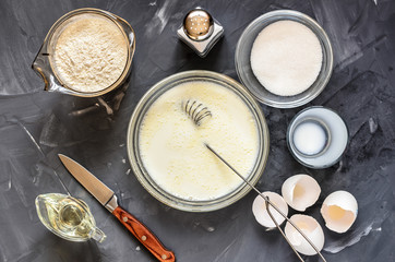 cooking  of Russian dishes pancakes: eggs, milk, flour, butter, salt. Top view