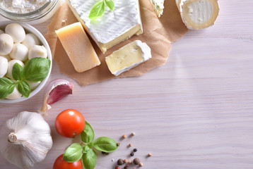 Creamy cheeses on white wood table top view
