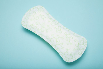 White menstrual pad isolated on blue background.