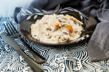 Tasty risotto with chicken, fresh herbs vegetables on a white plate
