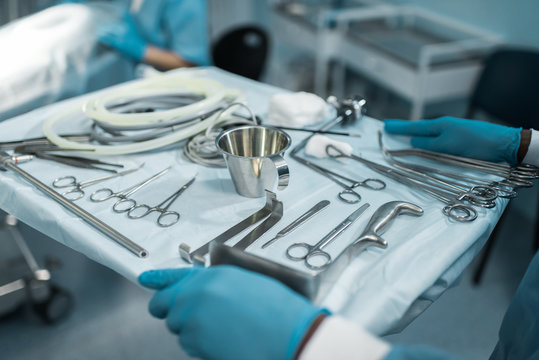 cropped image of african american doctor holding tray with medical tools for surgery