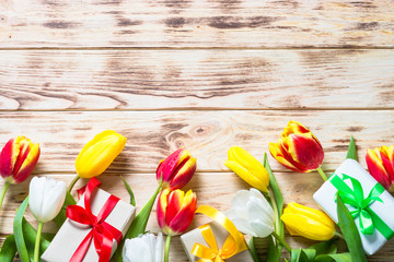 Tulips flower and present box on wooden table.