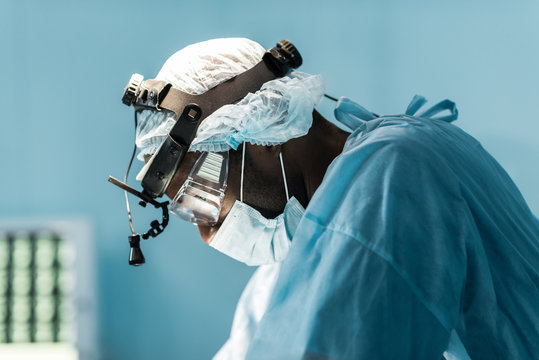 side view of african american surgeon in operating room