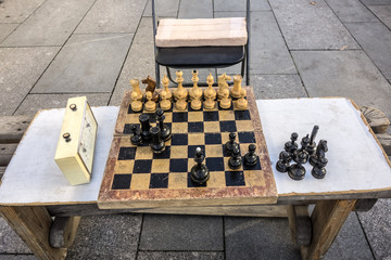 Old wooden chessboard, chess pieces and a chess clock